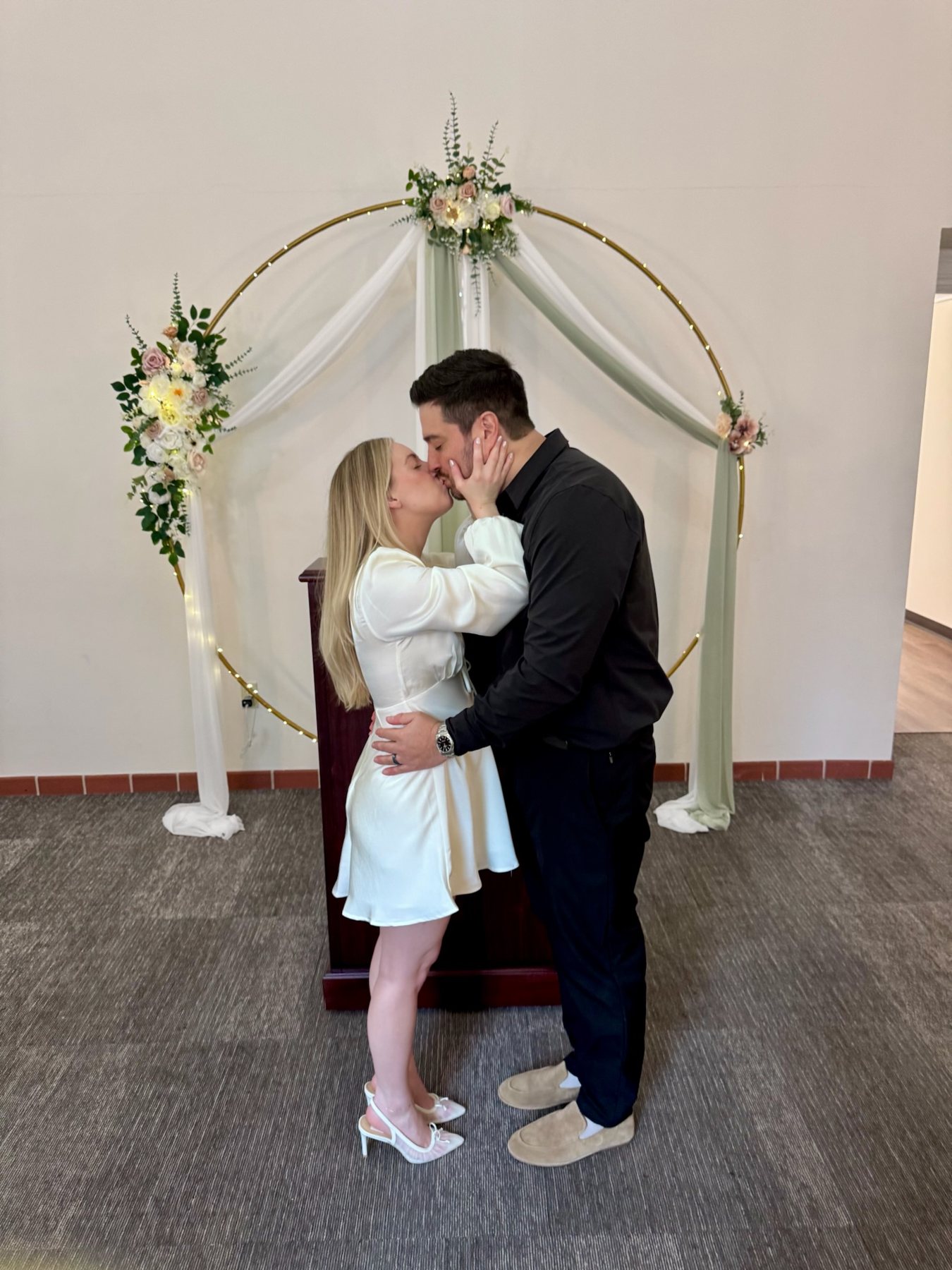 First kiss as husband and wife under the floral arch